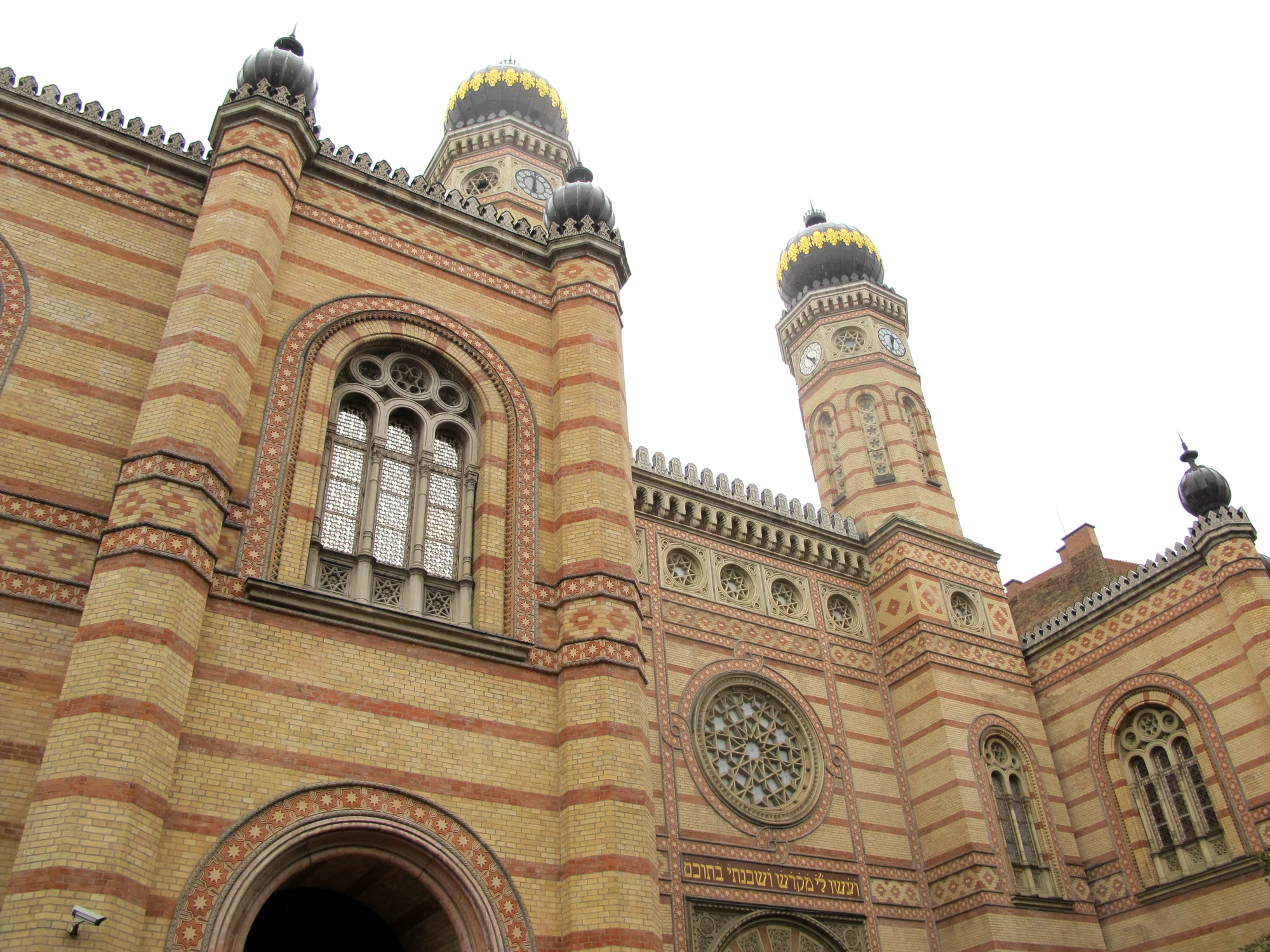 The patterned brick facade and twin domes of Dohány Street Synagogue in Budapest.